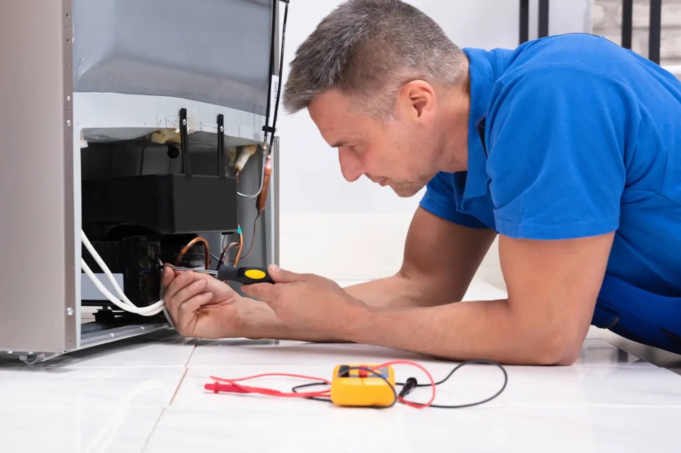 Technician examining the lower mechanical area of an ice-making appliance