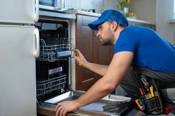 Technician inspecting the racks and interior of an open dishwasher