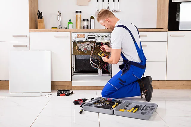 Technician checking oven components with a diagnostic meter